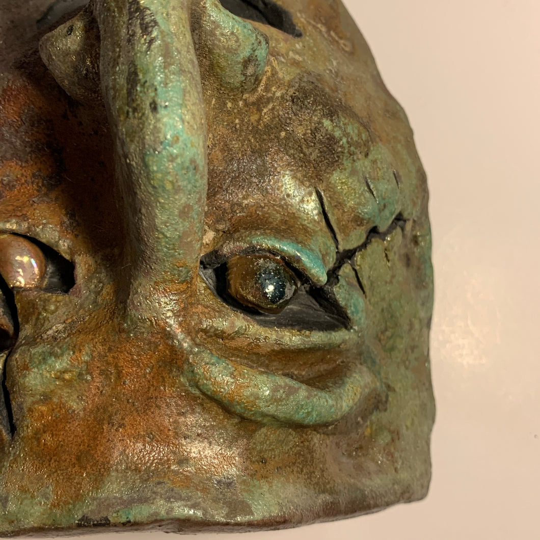 Raku clay sculpture mask, slit eye glazed stare. AGE